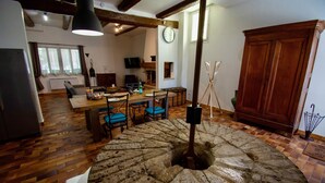 A dining area with a stone table, chairs, and a wooden cabinet. - LA MAISON DU MOULIN DE TARTAY EN AVIGNON (Avignon)