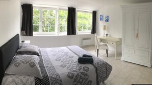A bedroom with a bed, a desk, and a wardrobe. - Single-storey house 125 m² facing the sea, patio with barbecue and garden. (Crozon)