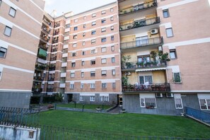 A multi-story residential building with balconies, a courtyard, and a gated entrance.