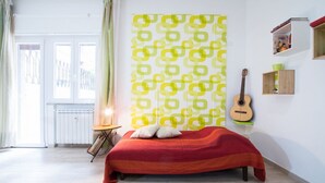A bedroom with a bed, a guitar, and a window with curtains. - Vintage Apartment Trastevere St. (Roma)