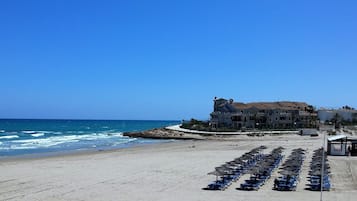 Una playa cerca, sillas reclinables de playa, toallas de playa