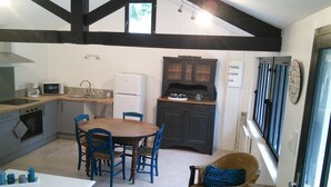 A compact kitchen with a dining area, a microwave, a refrigerator, and a small window. - At the water wire Perigord (Lisle)