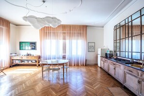A spacious kitchen with wooden cabinets, a large island, and a dining area with a table and chairs.