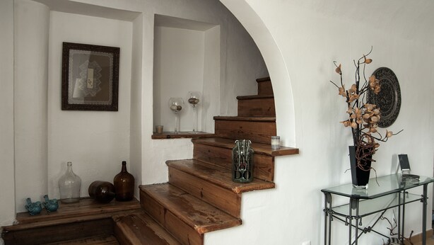 A staircase with wooden steps leading to a landing, a glass console table with decorative items, and a framed picture on the wall. - Casa Resende - Resende House (Évora)