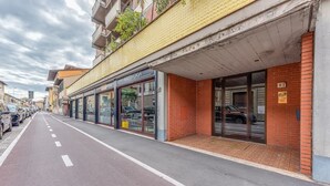 A street view with a row of shops, including a visible car dealership. - HOW I WAS HOME: LARGE SPACES, WIFI, BIKE AND PRIVATE PARKING AND FLORENCE IS YOURS! (Firenze)