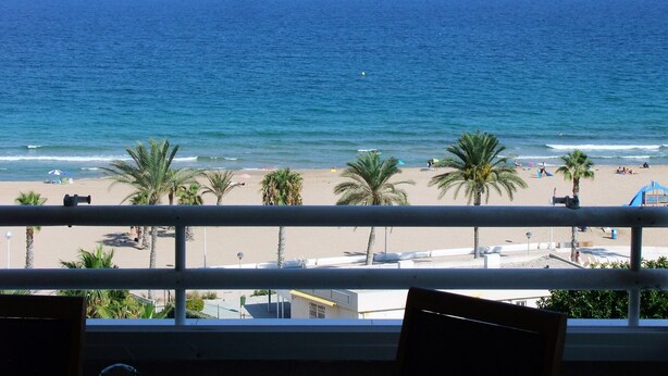 A beach view from a balcony with palm trees and umbrellas. - ALICANTE, GREAT VIEWS, SUN FOUR SEASSON AND BEACH (3 BEDROOMS) WIFI (Urbanova)