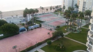 An aerial view of a residential complex with multiple tennis courts, palm trees, and a beach in the background. - ALICANTE, GREAT VIEWS, SUN FOUR SEASSON AND BEACH (3 BEDROOMS) WIFI (Urbanova)