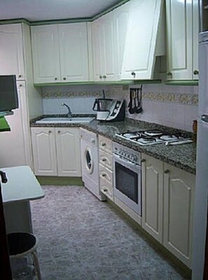 Enjoy cooking in this well-equipped kitchen with a stove, oven, and sink, and dine in the adjacent dining area.