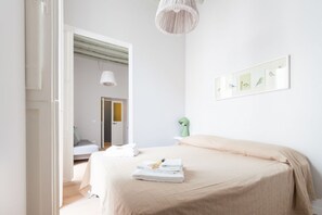 A bedroom with a bed, a wall-mounted artwork, and a door leading to another room. - Ideal Apartment Navona Square (Roma)