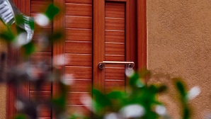 Uma porta de madeira com puxador de metal e parede com textura.