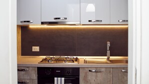 Uma cozinha moderna com eletrodomésticos de aço inoxidável, fogão a gás e forno embutido.