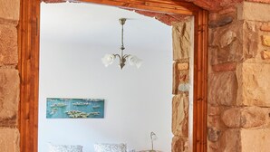 A bedroom with a bed, a nightstand, and a painting on the wall. - Stone corner in Barcelona (Corró d'Avall)