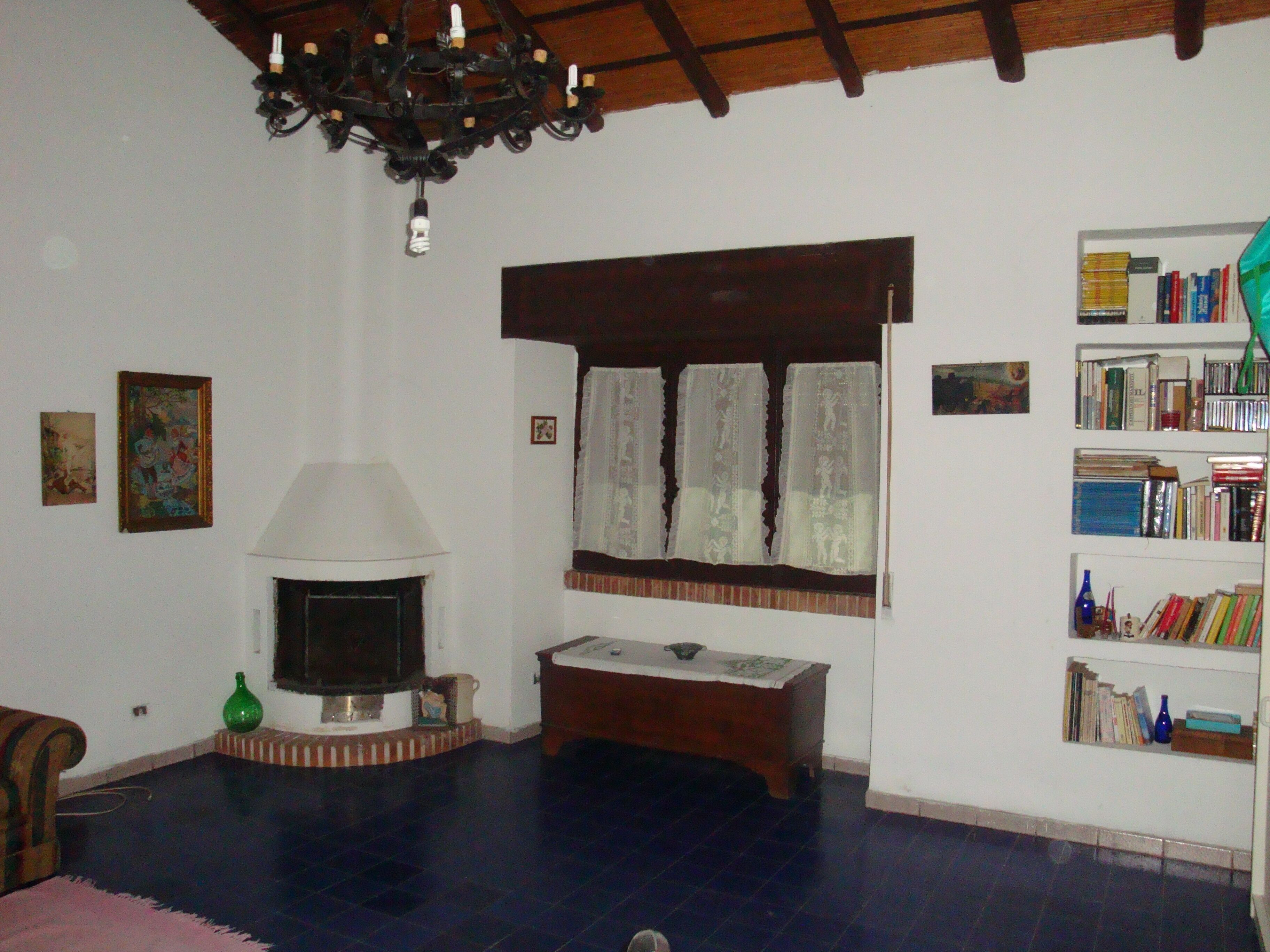 Ein Wohnzimmer mit Kamin, Bücherregalen und einer Chandelüster.