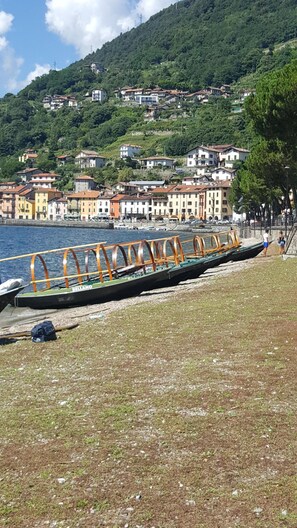 Una hilera de barcos amarrados en un muelle, con un pueblo en la ladera al fondo.
