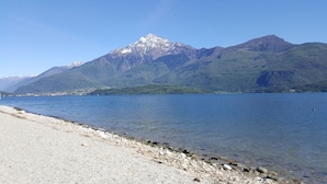 Un lac avec une montagne en arrière-plan et une rive rocheuse.