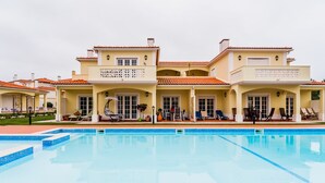 A large, two-story building with a swimming pool in front. - Apartment in Praia D'El Rey Golf & Beach Resort (Amoreira)