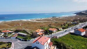 Uma cidade costeira com casas, uma estrada e uma praia.