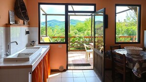 A kitchen with a sink, a window, and a view of greenery.