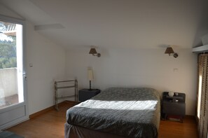 A bedroom with a bed, a nightstand, a lamp, a window, and a door. - Quiet "provençale" villa - Quiet Provencal villa. (Salon de Provence)