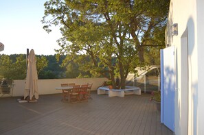 An outdoor patio with a table and chairs, a covered seating area, and a tree. - Quiet "provençale" villa - Quiet Provencal villa. (Salon de Provence)