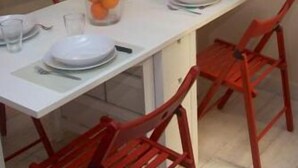 A dining area with a white table, red chairs, and a fruit bowl. - LOFT UNDER HOUSING CENTER OF VALENCIA- CIUTAT VELLA (València)
