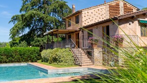 A house with a swimming pool, stone steps, and a pergola.