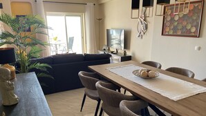 Zona de menjador amb taula de fusta, cadires de vimetla i un plat decoratiu sobre la taula.