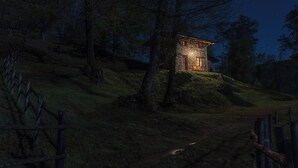 Une maison en pierre située sur une colline, avec un chemin de terre qui y mène.