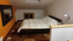 Een slaapkamer met een bed, een spiegel, een radiator en een lamp.