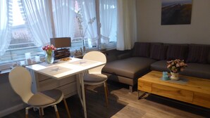 Uma sala moderna com área de jantar, um sofá e uma mesa de centro.