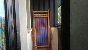 Un couloir étroit avec une porte en bois et un rideau à rayures.