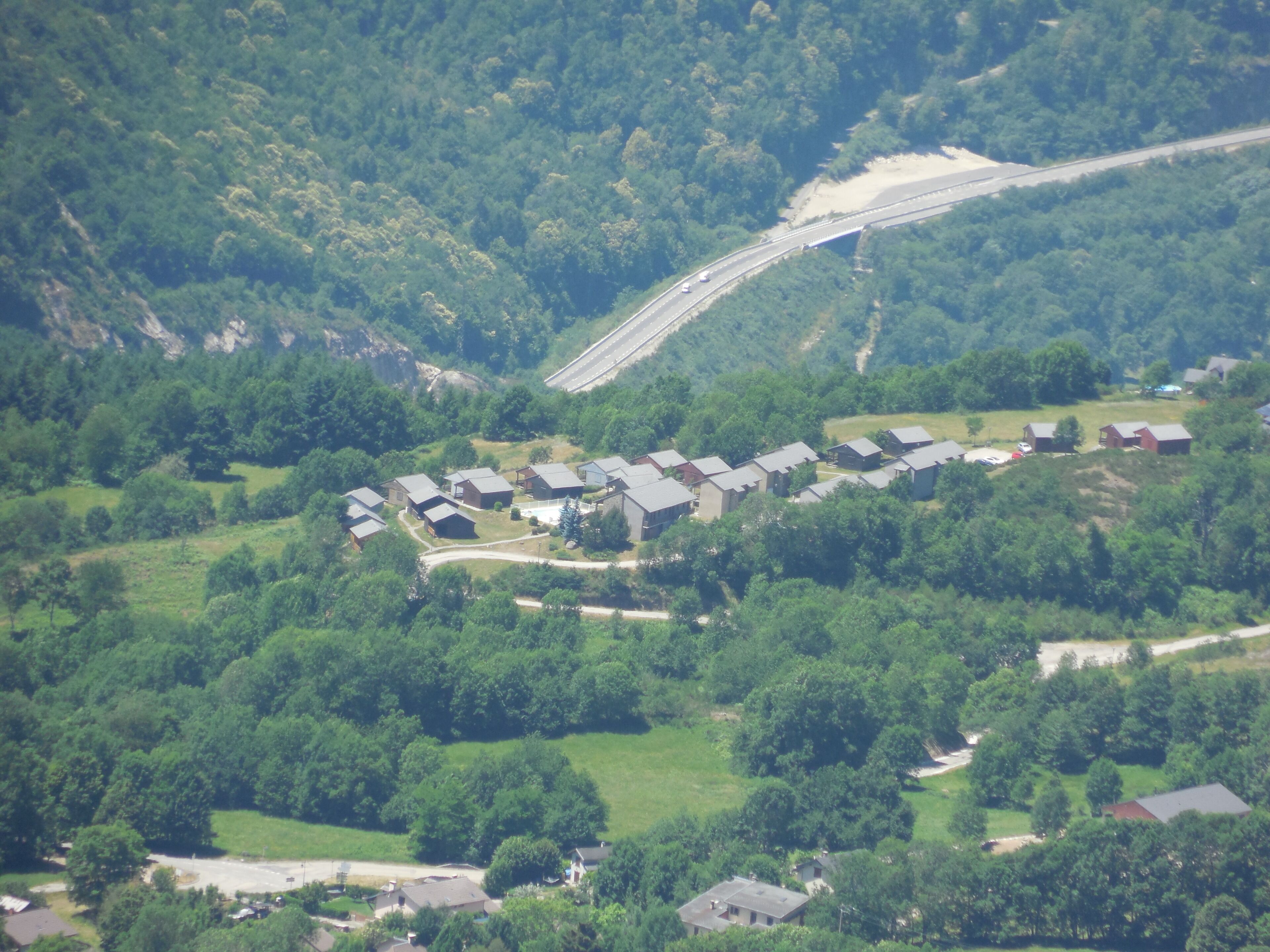 Zona residenziale con diverse case, una strada e un ponte.