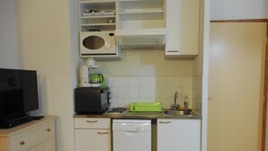 A compact kitchen with a microwave, toaster, and dishwasher.
