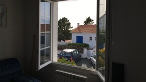 Une pièce avec une fenêtre donnant sur une rue résidentielle.