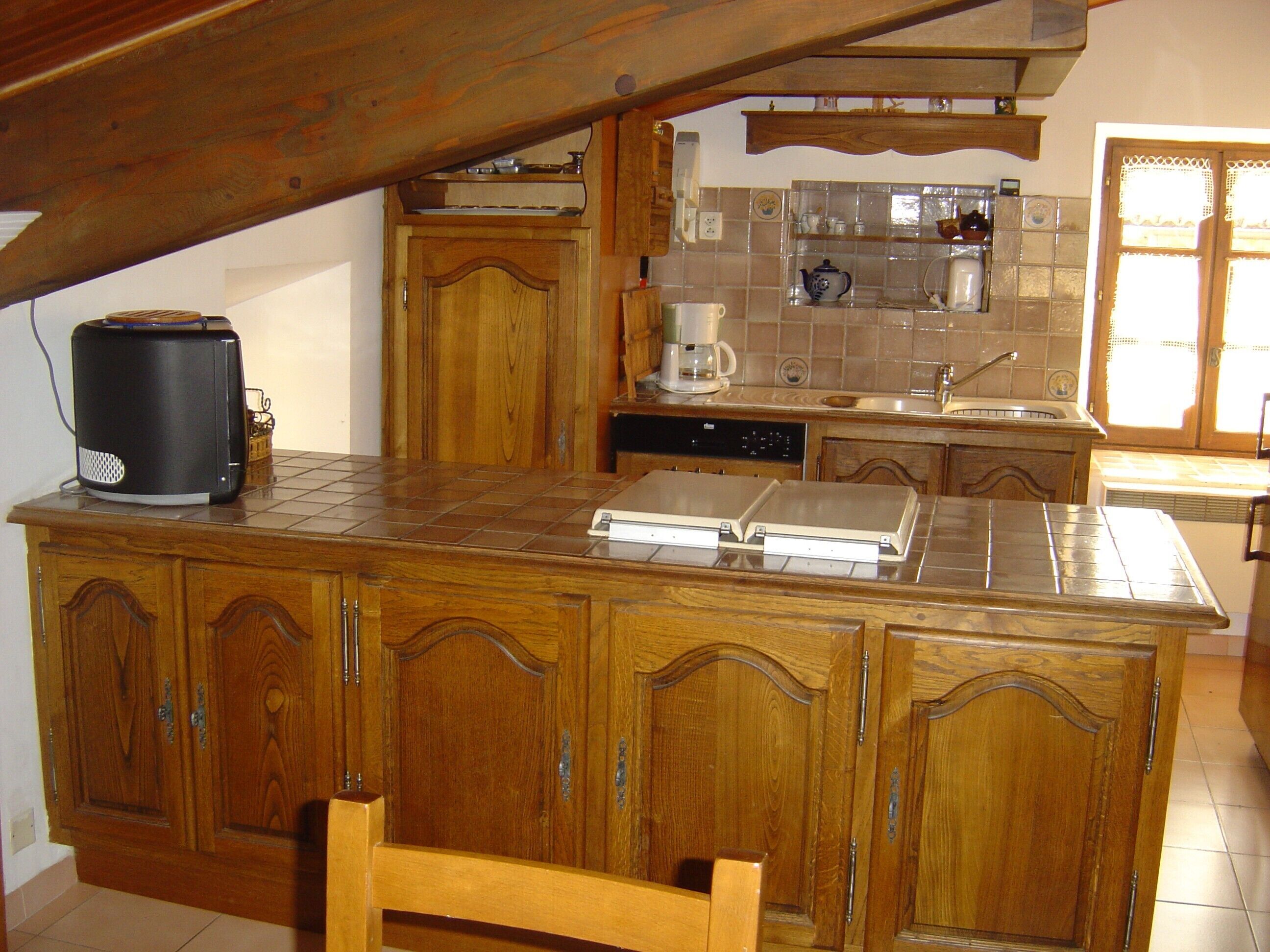 A kitchen with wooden cabinets, a coffee maker, and a toaster.