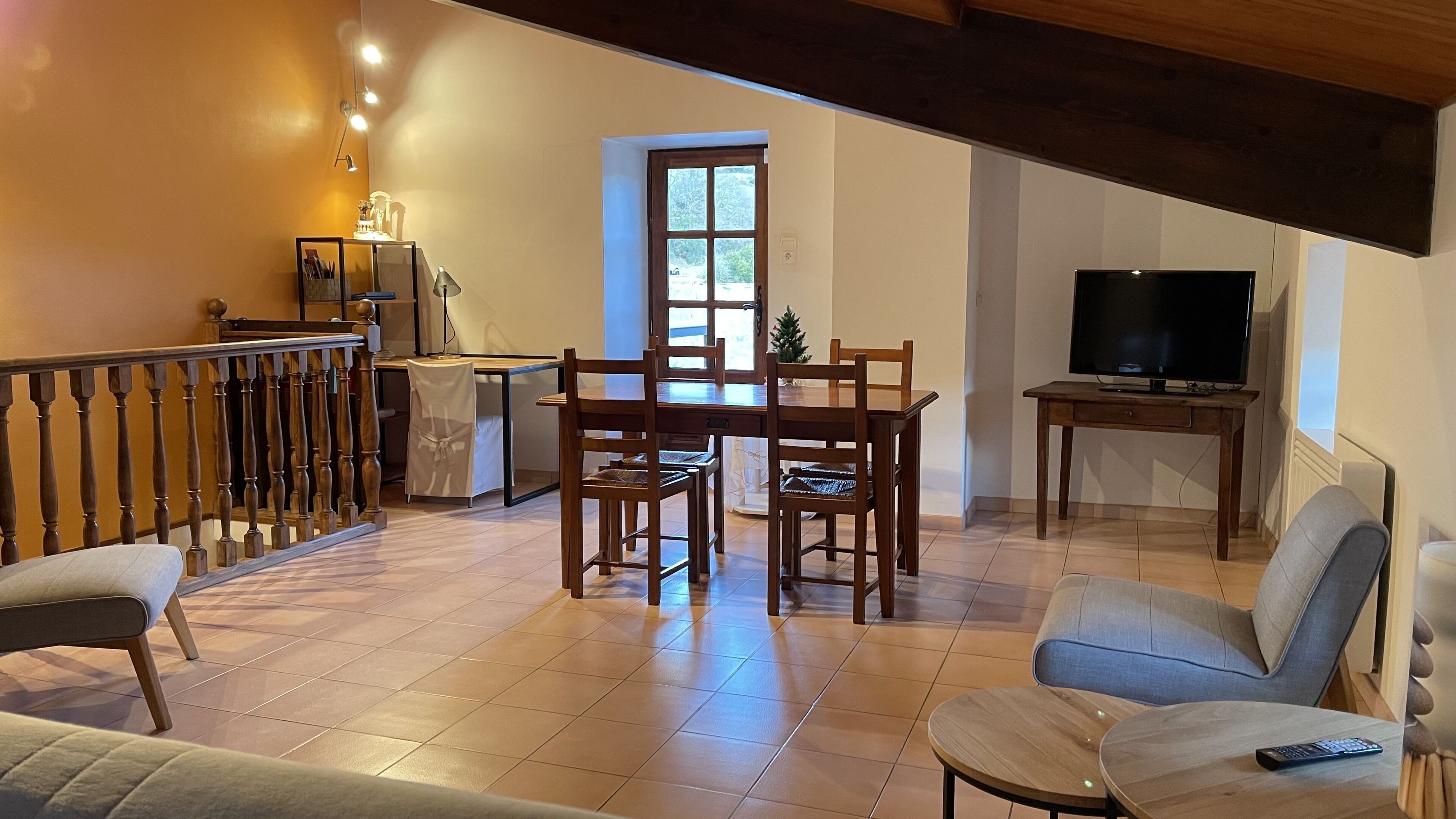 Un grand espace de vie comprenant une table à manger, des chaises, un canapé et un téléviseur.