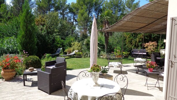 An outdoor patio area with a round table, wicker chairs, and a covered seating area. - Typical and luxurious house in the very heart of provence with swimming pool . (Vaucluse)