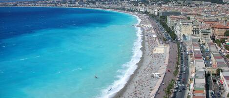 Ranta lähistöllä, aurinkotuoleja, rantapyyhkeitä