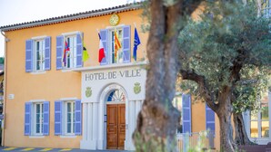 Een gebouw met het bord "HOTEL-DE-VILLE" en verschillende vlaggen, waaronder de Franse vlag.