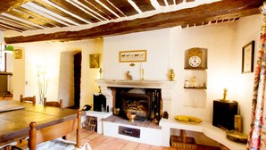 Un interior rústico con chimenea, muebles de madera y un reloj en la pared.