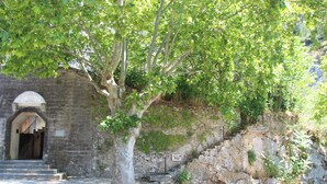 A stone building with a staircase leading to an arched entrance. - Gîte le chat vert. The most beautiful villages in France  (Robion)