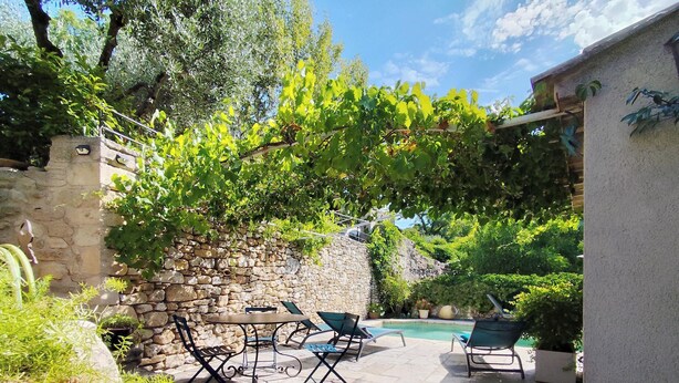 A patio with stone walls, a pool, and outdoor furniture. - Gîte le chat vert. The most beautiful villages in France  (Robion)