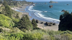 A coastal landscape with a beach, rocky outcrops, and dense greenery. - A Romantic Getaway at the "White Water Cove" At Ocean View Rainbow Rock!  (Brookings)