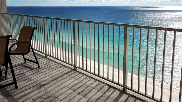 Een balkon met uitzicht op zee en een stoel.