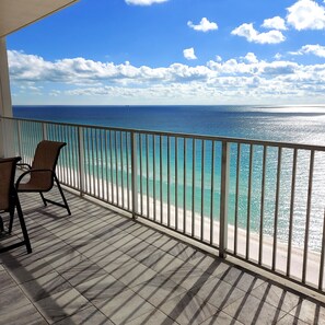 Un balcon avec vue sur l’océan et une chaise.