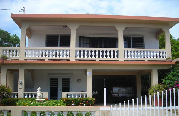Un edificio a due piani con un balcone, un garage e un cartello con il numero 845.