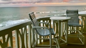 Een balkon met twee stoelen en een tafel met uitzicht op de oceaan.