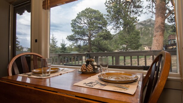 A dining table set with plates, glasses, and a decorative pine cone centerpiece. - Cozy 2-Cabin Retreat Near RMNP - Estes Park License #3051 (Estes Park)