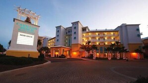 A hotel with a sign indicating it is now open. The building has multiple floors and balconies. - On 30A Water lovers dream!! 4 gorgeous pools, Lake and Ocean . Pet Friendly (Panama City Beach)