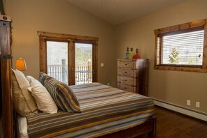 A bedroom with a bed, a dresser, and two windows. - Spacious mountain condo. Awesome views, Jacuzzi Tub. (Estes Park)